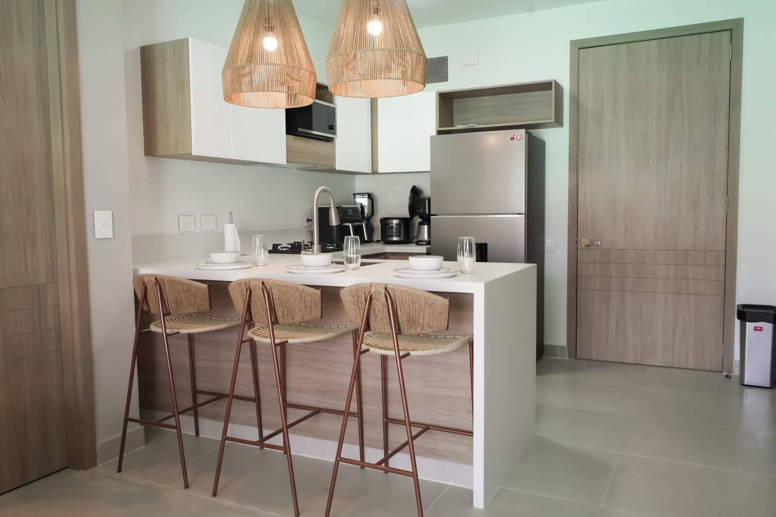 Cocina con barra y panel de listones de madera instalado por Reddy en Cartagena