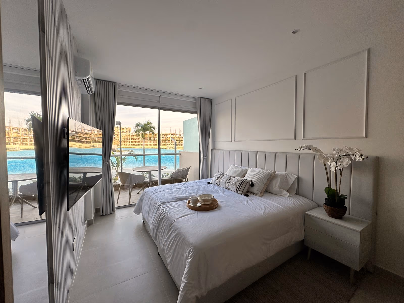 Habitación con cabecera tapizada, molduras y terraza con vista a la laguna, dotada por Reddy en Cartagena